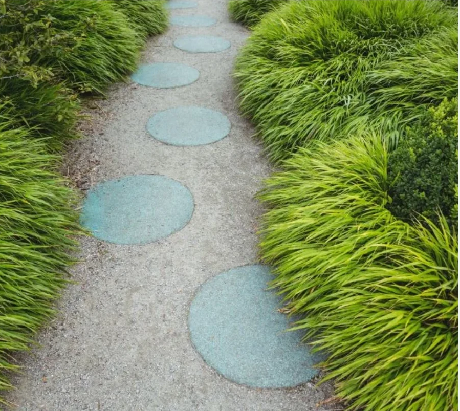 Tuinpad met stapstenen tussen siergrassen